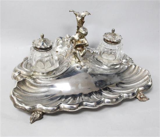 A late Victorian silver plated shell shaped inkstand, with two wells and central figural pen holder, width 28.3cm.